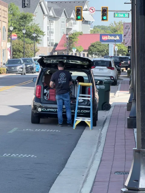 ICU Protection technician and branded service vehicle working on-site in downtown Conway